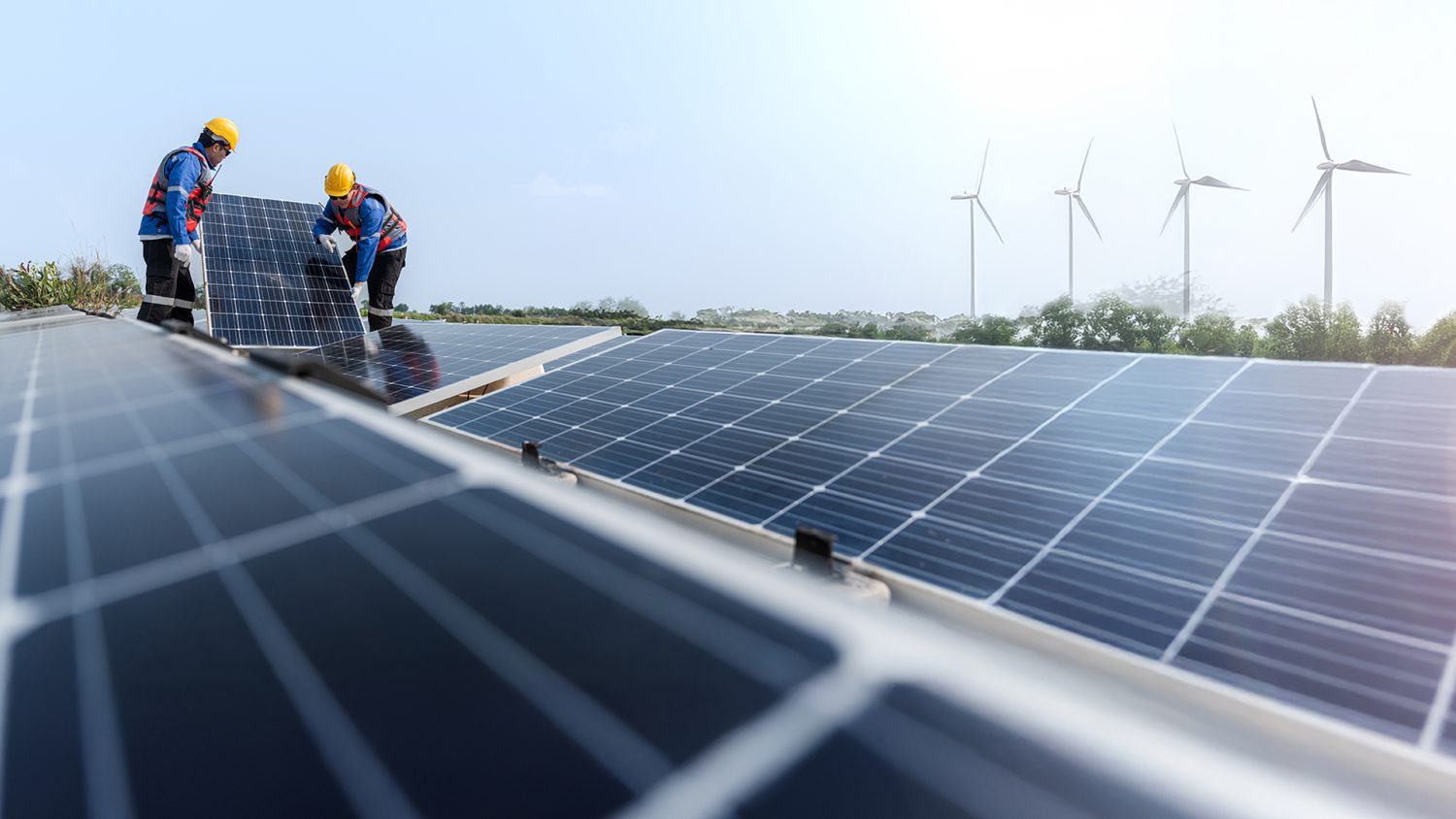 Male workers repair floating solar panels on water lake